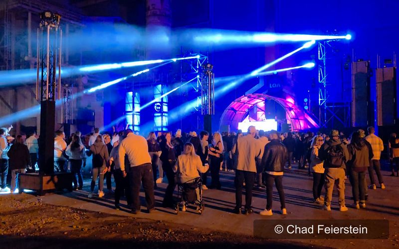 Blau und pink beleuchtete Festivalbühne mit Lichtstrahlen und Publikum beim LOA Closing 2025 in Luxemburg