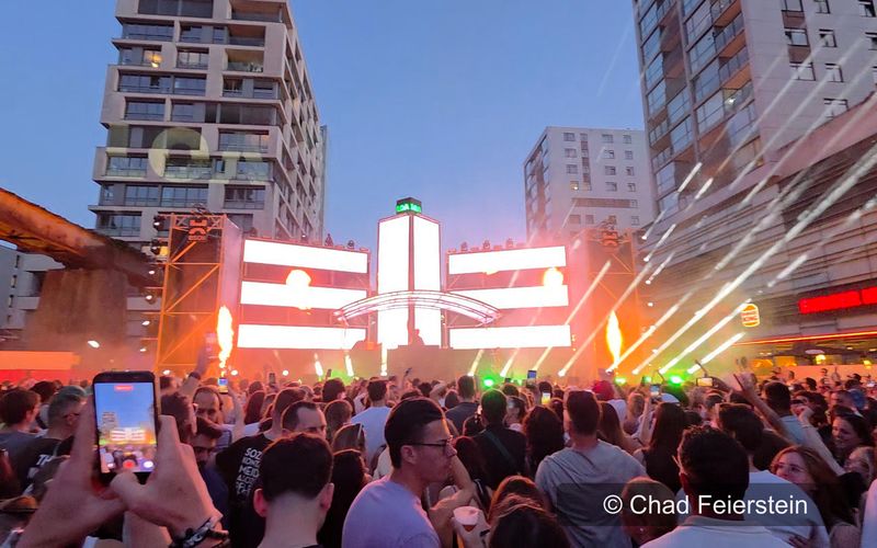 Festivalbühne mit Flammen, Lichtstrahlen und Publikum beim LOA Opening 2026 in Luxemburg in der Abenddämmerung